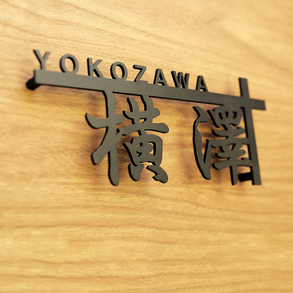 漢字を横長サイズになるようデザインしたアイアン表札の設置写真